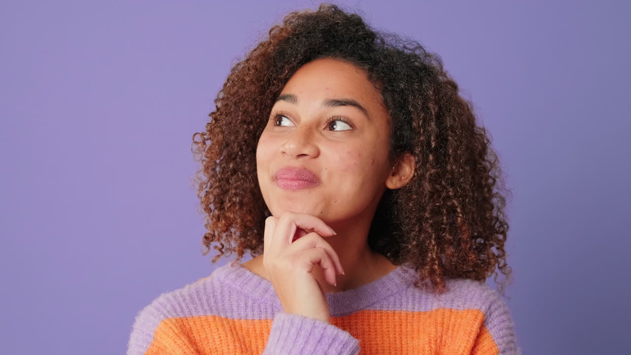 Thoughtful Young Woman with Curly Hair Thinking and Smiling