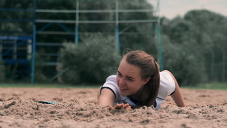 Slow-motion:-a-Young-woman-jumping-in-the-fall-hits-the-ball-on-the-sand.-Volleyball-player-makes-a-team-and-plays-the-ball-off-in-the-fall.