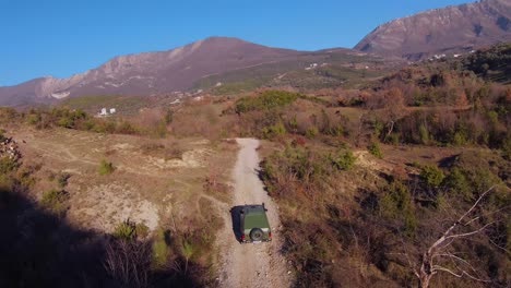 Schnelles-Rallye-Offroad-Auto,-Das-Aus-Dem-Schatten-Des-Hügels-Auf-Den-Feldweg-Kommt