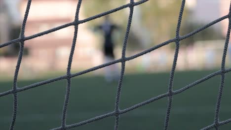 Fußballnetz-Mit-Dem-Torhüter-Im-Hintergrund-Verschwommen