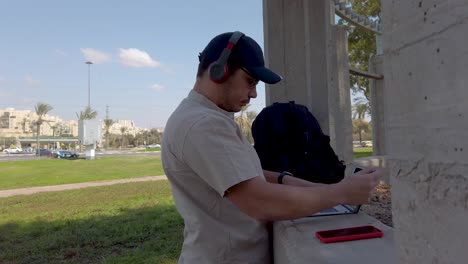 young man using his tablet in a park on a sunny day.