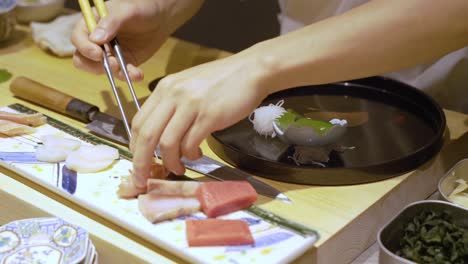 chef preparing side dishes for sushi in a chinese restaurant in guangzhou, china - close up