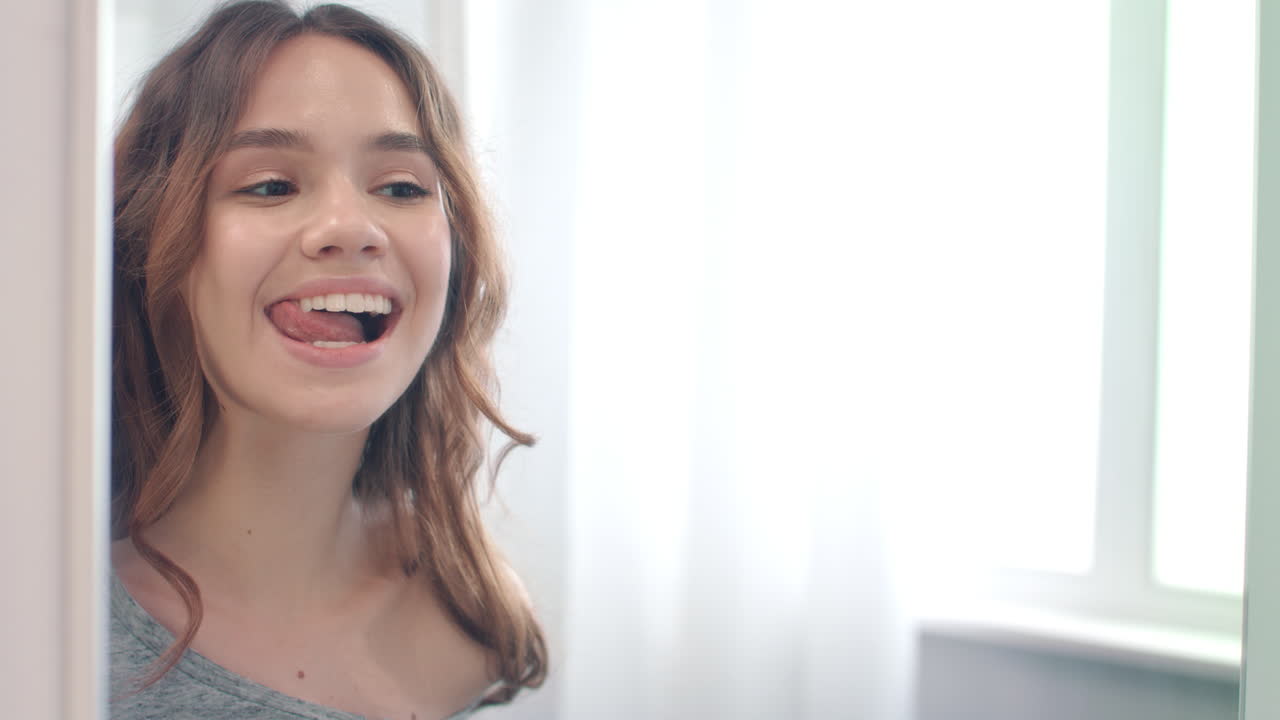 Smiling woman licking clean and white teeth