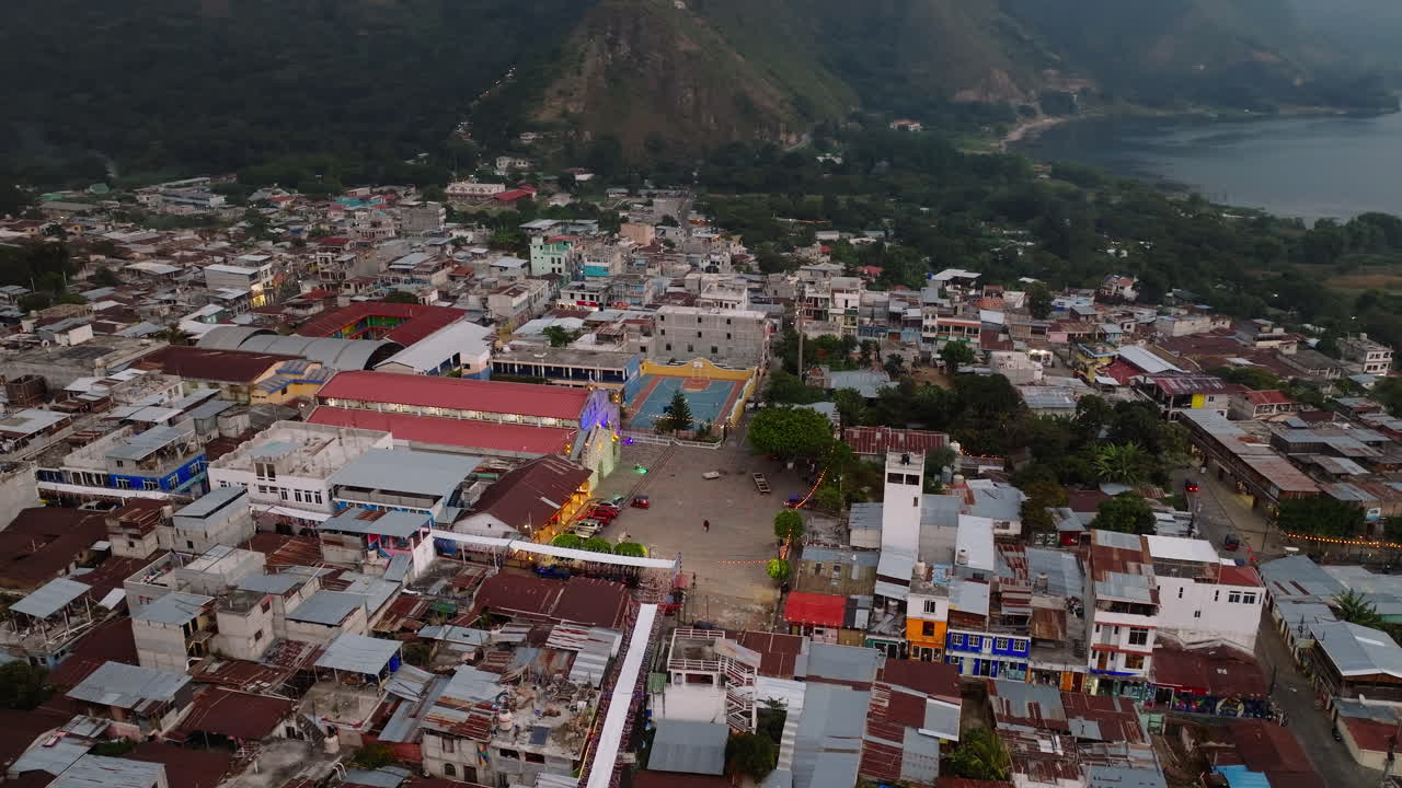 Aerea: Lenta panoramica della Chiesa Cattolica nel villaggio di San Juan La Laguna sul Lago Atitlan, Guatemala, durante una giornata nuvolosa.