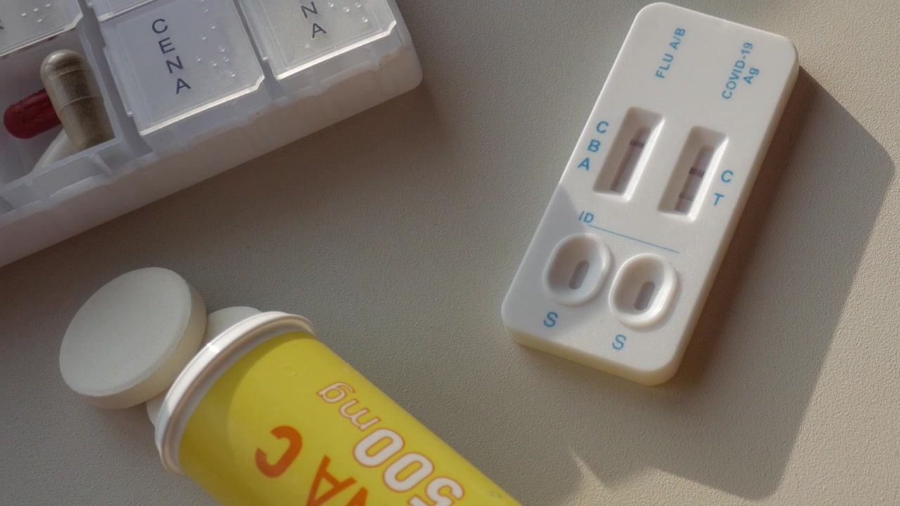 Close-up of a table with Covid test, thermemeter and medicines. Panning view