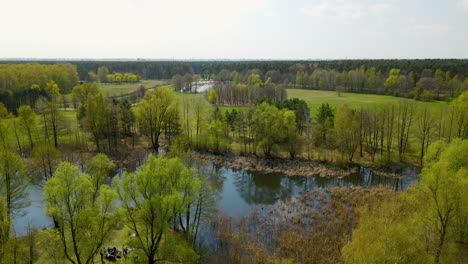 Aerial-view-of-over-natural-park-area-with-lakes-and-green-colored-meadow-in-autumn---Poland,Europe