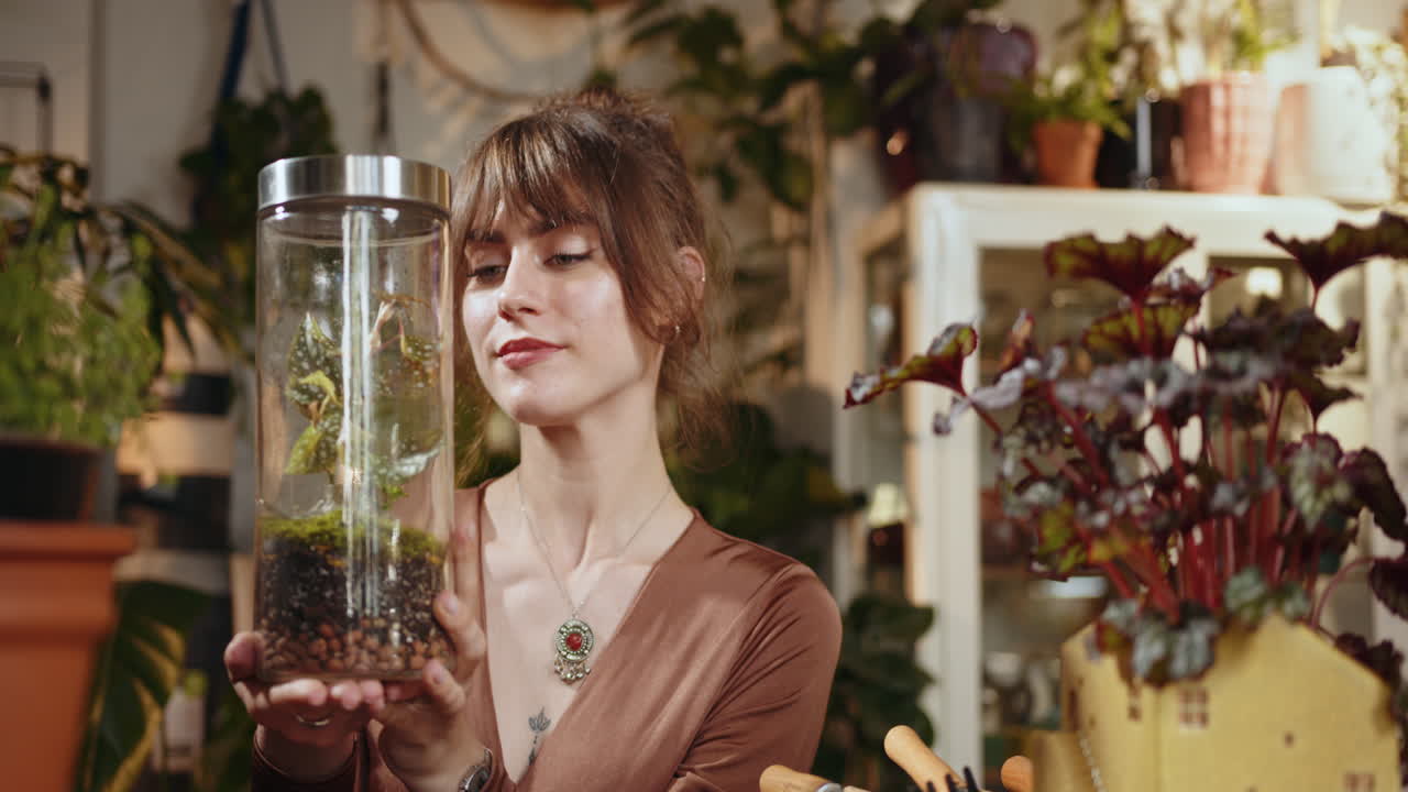 mujer sosteniendo un terrario en una tienda de plantas
