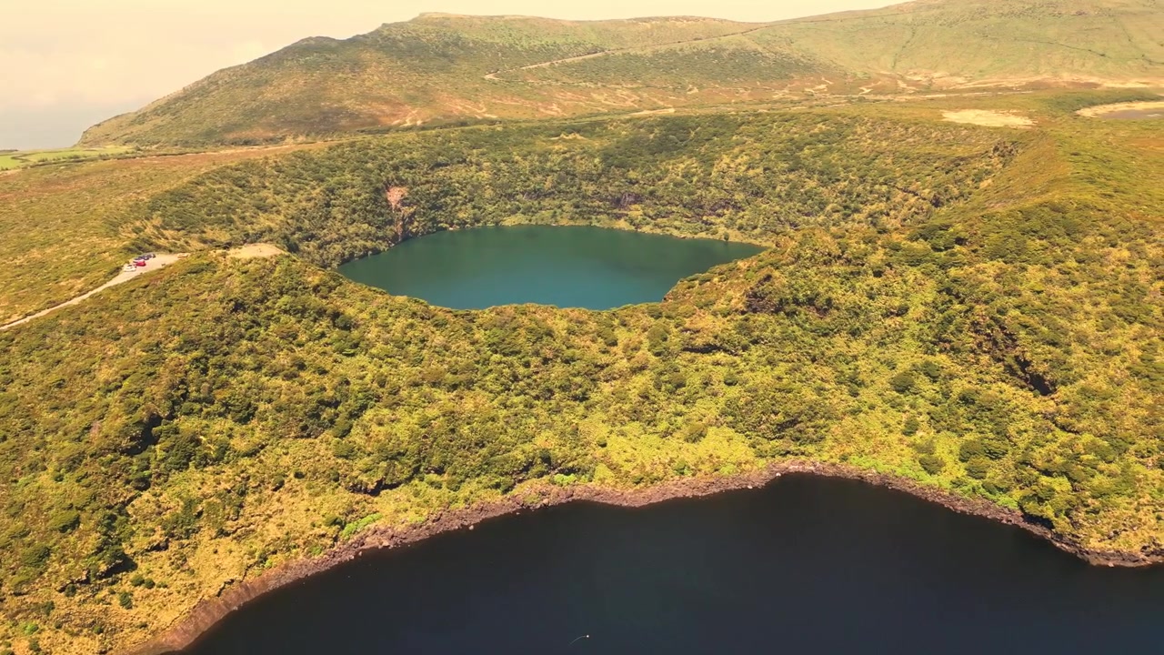 Vista aérea de lagos gêmeos de crateras vulcânicas cercados por colinas verdes exuberantes na Ilha das Flores