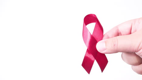 detail of male hand putting ribbon in red color on white background