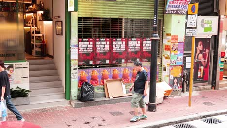 pedestrians pass by a storefront in hong kong