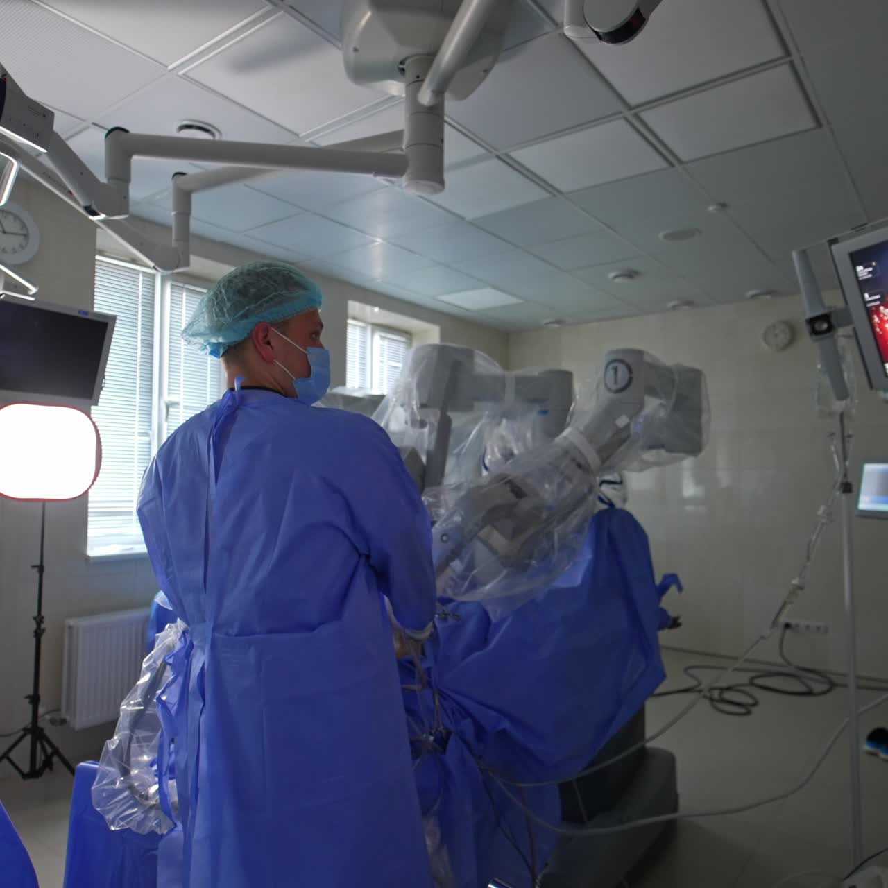 Doctor looks at the screen with operational site macro image. Camera slowly moving to the monitors with life signs of a patient under surgery