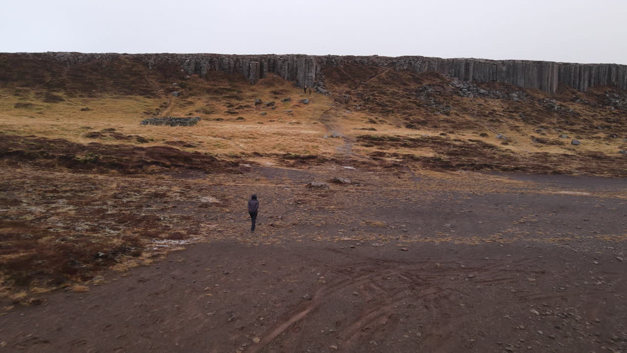 Aerial shot of a woman wondering in Gerouberg Cliffs in Iceland