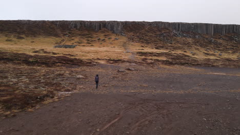 Aerial-shot-of-a-woman-wondering-in-Gerouberg-Cliffs-in-Iceland