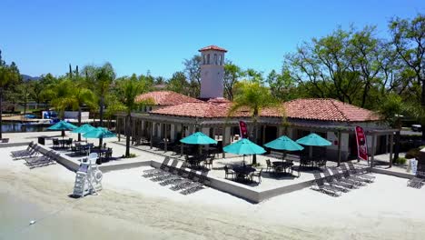 aerial descent in front of lake club at a community sand lagoon pool