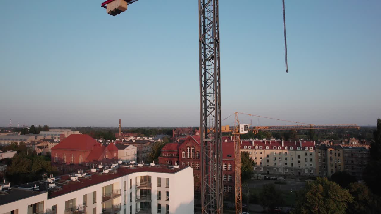 Aerial view of construction site, revealing tall tower crane. Building project in city
