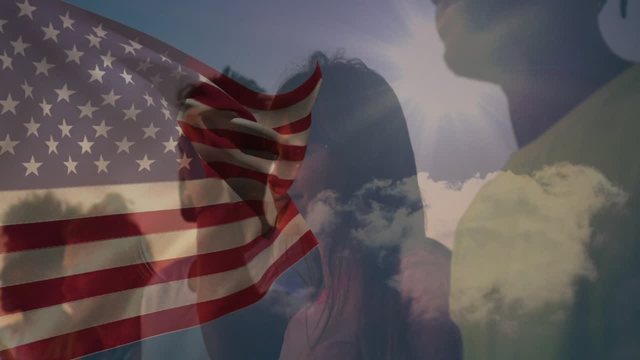 American flag waving, people standing under cloudy sky, feeling patriotic atmosphere