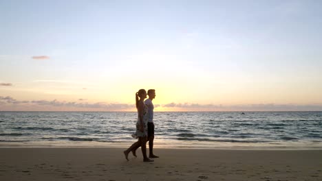 cheerful family walks along empty ocean beach joining hands