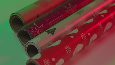 Rotating-Christmas-tree-icon-wrapping-paper,-vibrant-red-green-two-light---slow-motion-close-up-pan-left