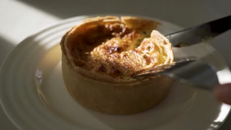 cutting the first slice from a scrumptious cheese quiche