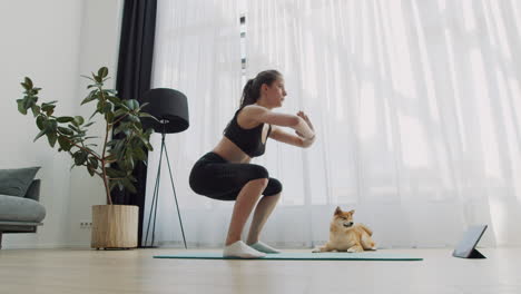 Eine-Junge-Frau-Macht-Zu-Hause-Yoga-Mit-Ihrem-Hund-Neben-Sich-1