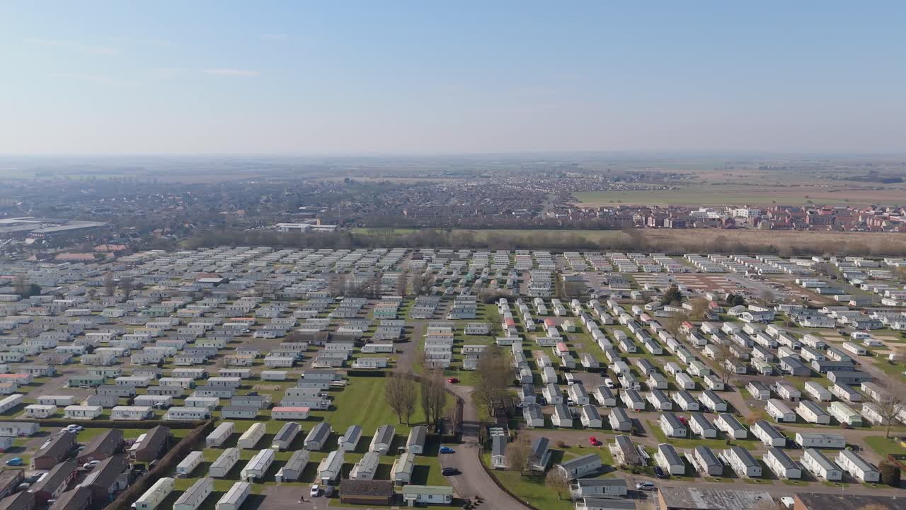 Warm light bathing the coastal holiday town of Skegness in Lincolnshire. Aerial views of hotels houses, theme parks and static holiday homes. Destination and tourist vacation, summer evening scene