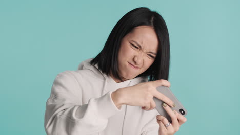 Asian-woman-playing-video-games-on-smartphone-and-winning.