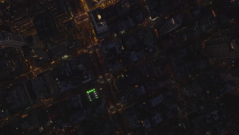 Aerial-birds-eye-overhead-top-down-ascending-view-of-traffic-in-streets-in-night-city.-Manhattan,-New-York-City,-USA