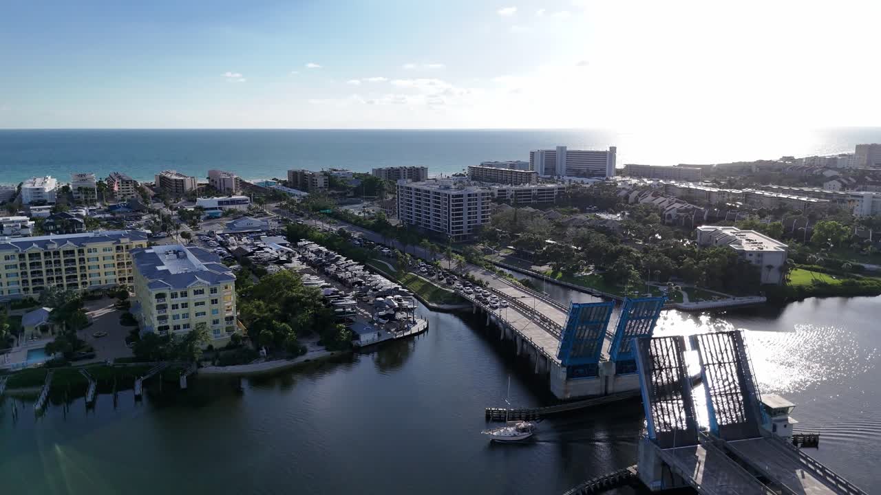 sailboat moving under the open Stickney Point Bascule Bridge connecting Siesta Key Island with south Sarasota, Florida