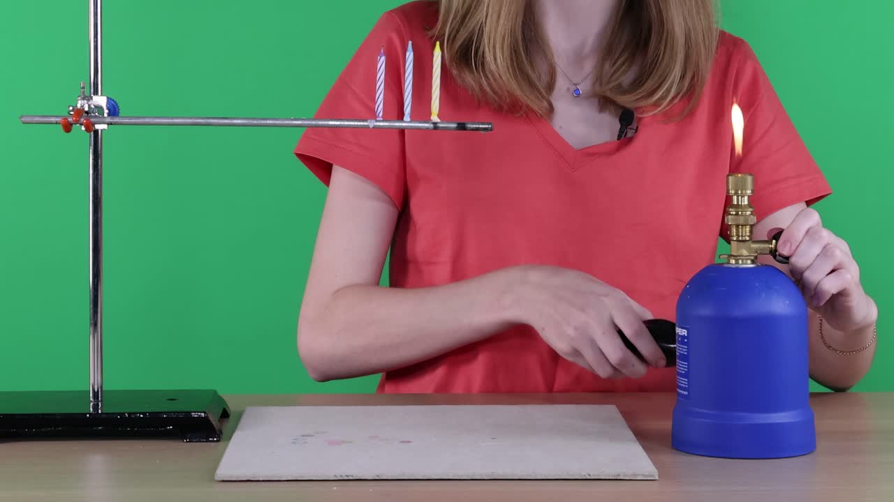 A science experiment demonstrating heat conduction using a Bunsen burner and metal rods in a controlled environment