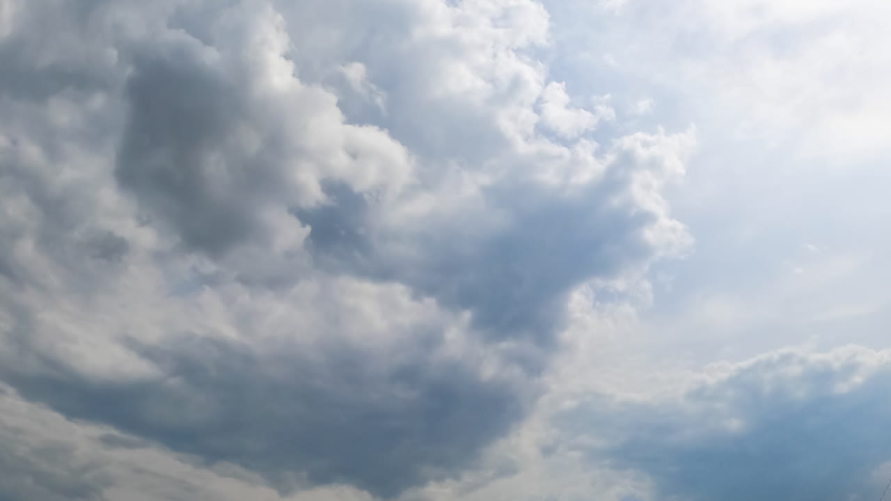 Formation of rain cloudscape in the atmosphere. Grey overcast sky from low angle view. Timelapse.