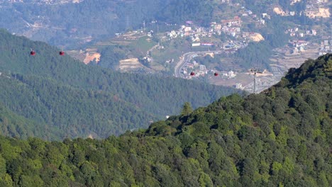 cable cars going up and down the cables on the side of a hill in nepal