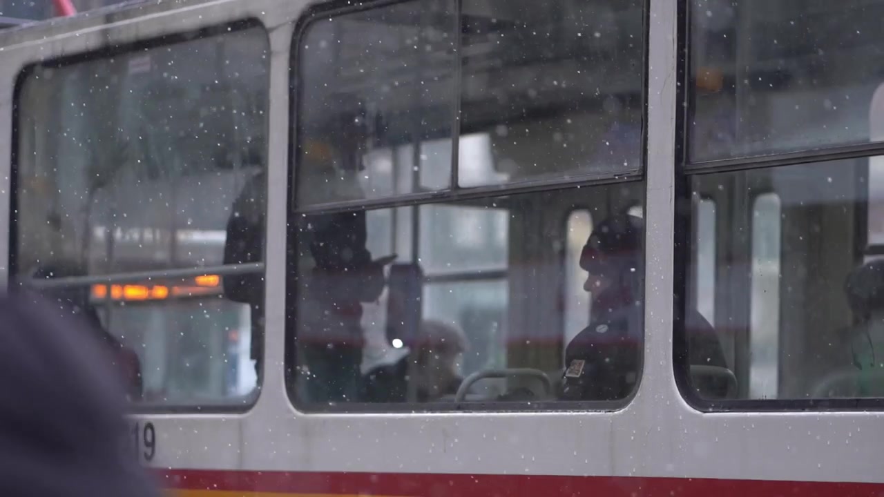 La neve cade al rallentatore mentre i pendolari viaggiano su un caldo tram della metropolitana dopo il lavoro, Bulgaria