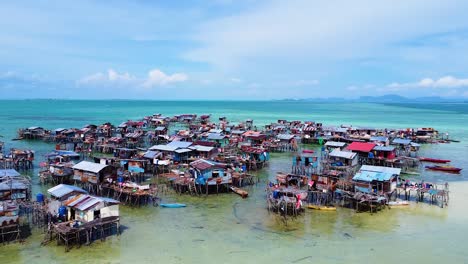 revealing landscape drone shot of pulau omadal with sea houses of the sea nomads