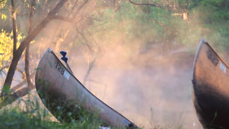 Canoes-on-shore-on-river-bank-and-lake-in-the-forest