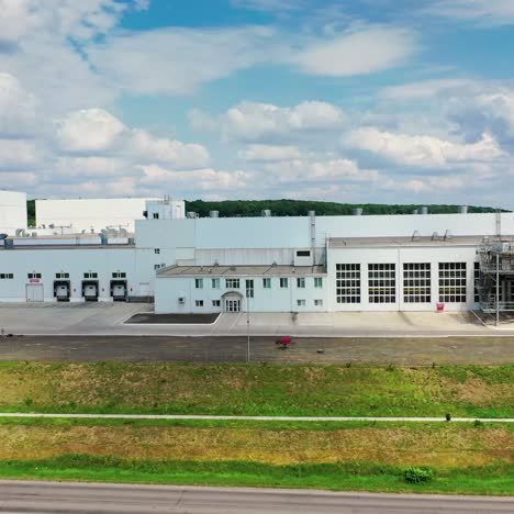 industrial complex under blue sky. innovative manufacturing near the road. industry in nature. motion camera to the right
