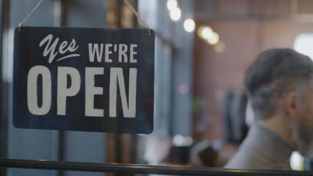 Store Owner Changing Signs: Open and Closed