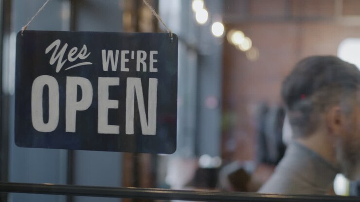 Store Owner Changing Signs: Open and Closed