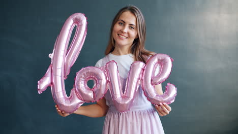 woman holding pink love balloons