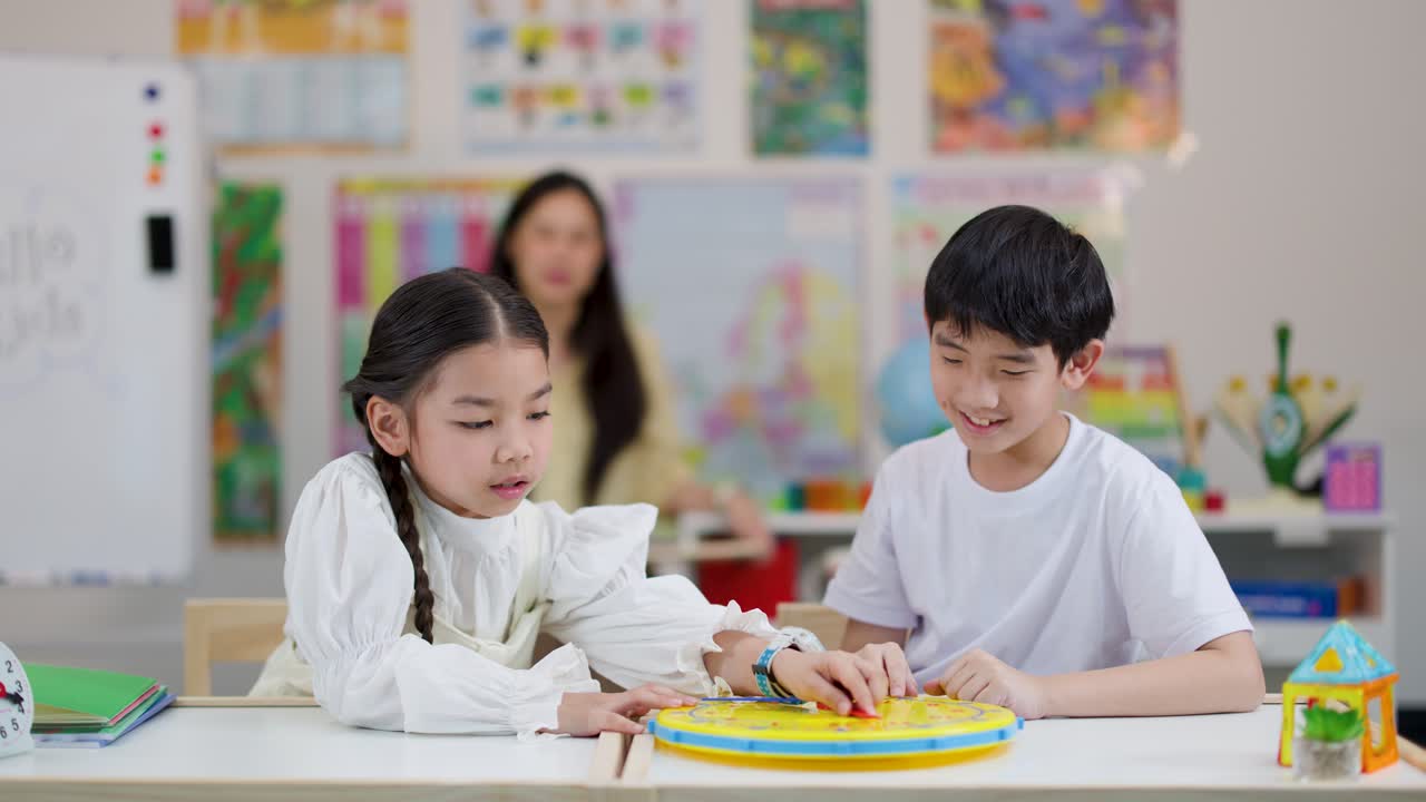 Two children interact with a clock toy, guided by teacher, in a brightly lit classroom