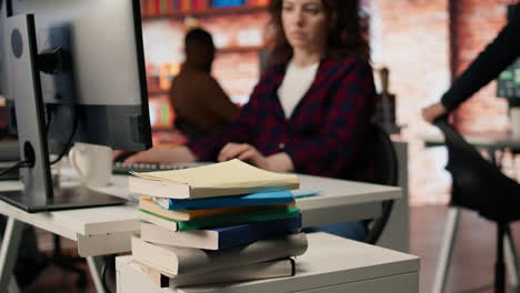 close up of books on startup office desk used by entrepreneur to grow business