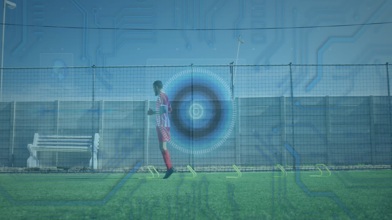 Microprocessor connections and round scanner against male soccer player practicing on grass turf
