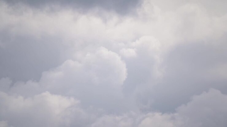 Telephoto timelapse of dense clouds churning and reshaping in close view. Compressed perspective emphasizes swirling texture, layered movement and dramatic atmospheric detail.