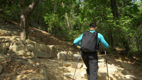 Lone-hiker-walks-uphill-mountain-forest-trail