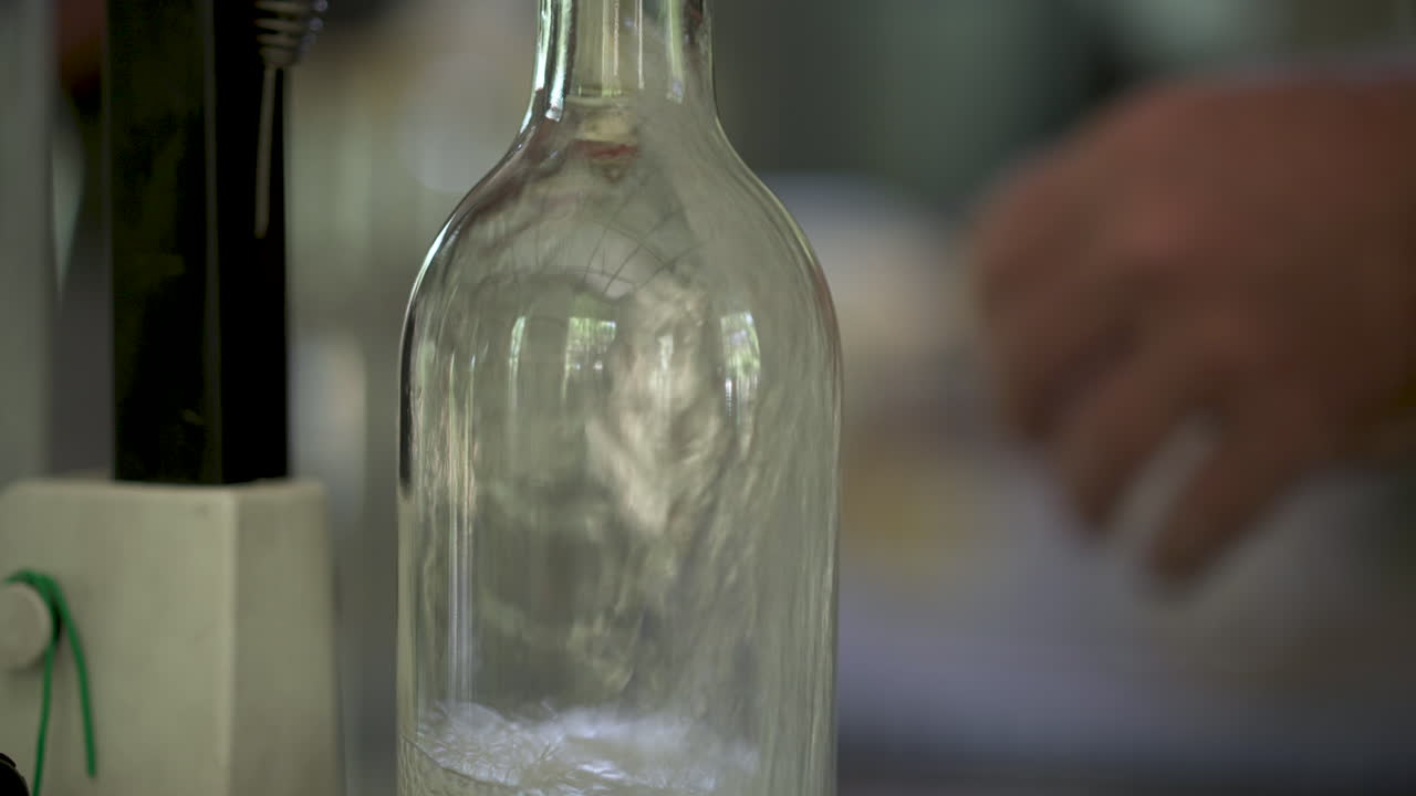 Close up of artisan gin being filled into glass bottle at a small artisanal distiller