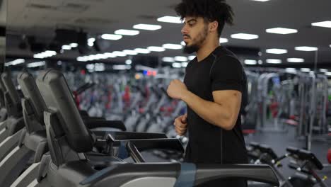 Runner-man-training-on-treadmill-machine-at-workout-in-fitness-center