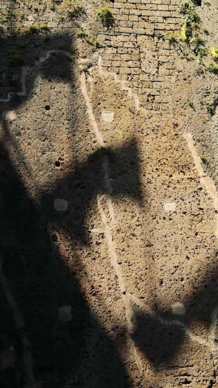 тень флага движется через историческую стену сорренто.