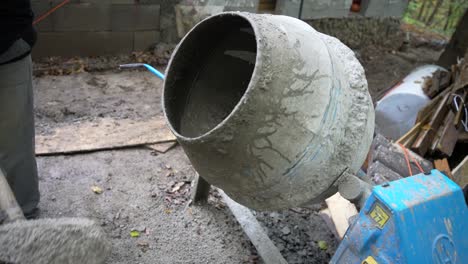 trabajador cubriendo con palas la grava en una mezcladora de cemento