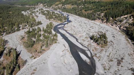 Imágenes-Aéreas-De-Un-Valle-Largo-Y-Plano-Con-El-Río-Fantasma-Fluyendo-A-Través-De-él