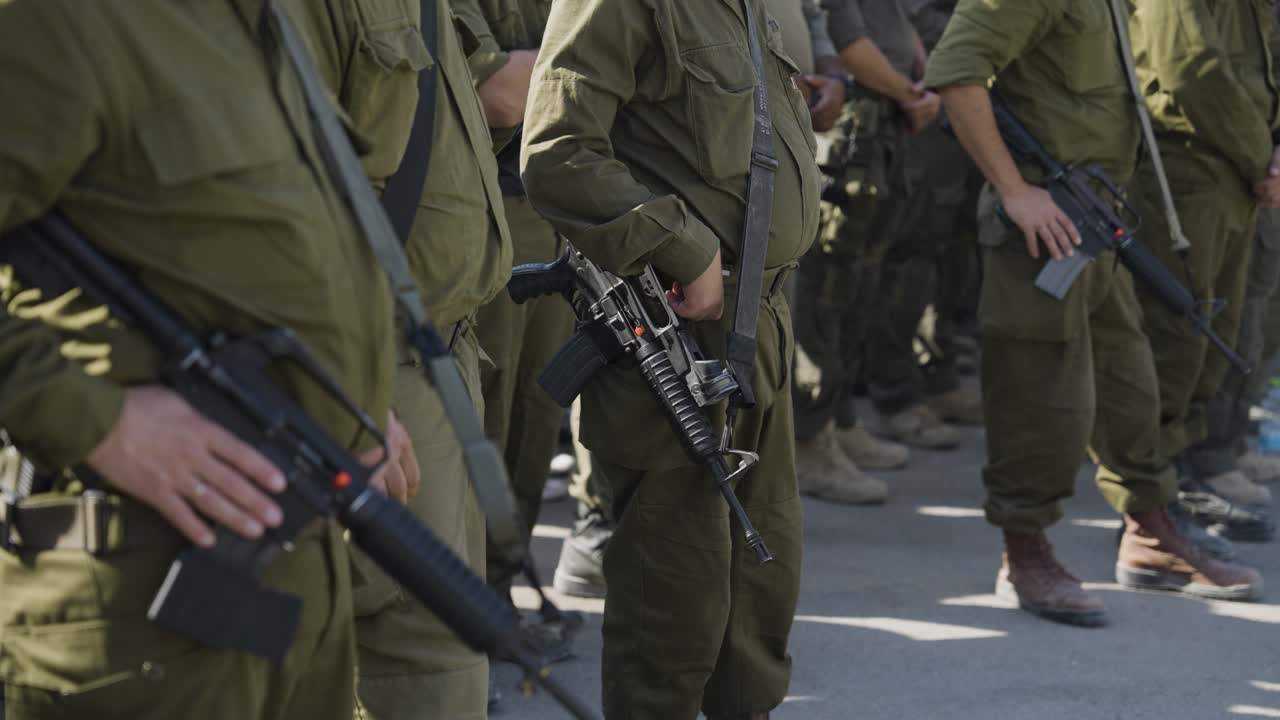 IDF military with assault rifles standing in queue, Golan Heights Israel conflict, Gaza