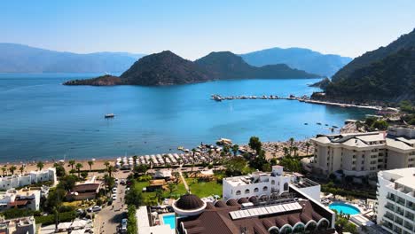 flying drone over the resort town and hotels against the background of the mediterranean sea blue sky beach and bay with mountain island road